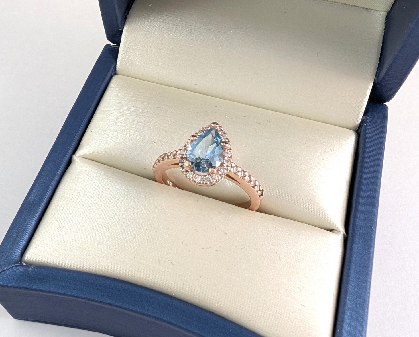 14K rose gold custom engagement ring in a blue ring box
